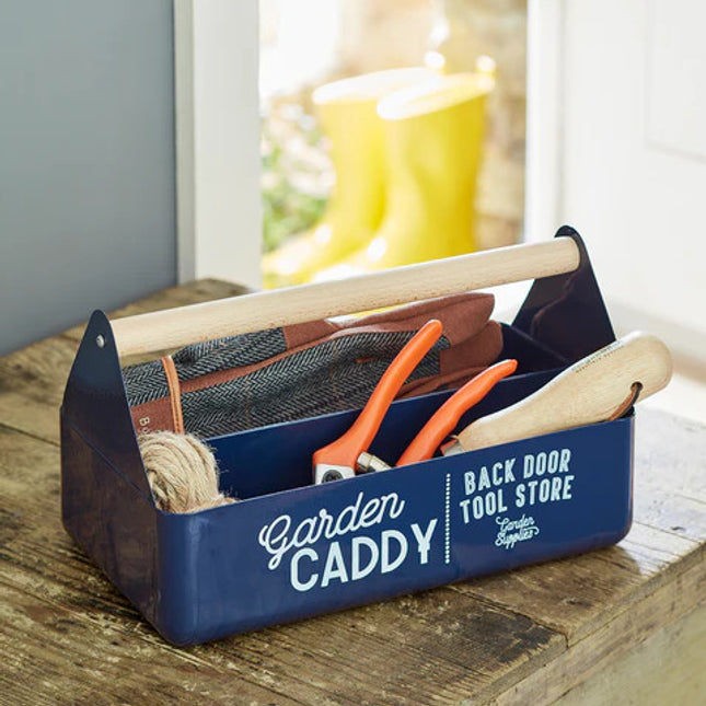 the blue garden caddy on a wood tabletop and filled with miscellaneous tools