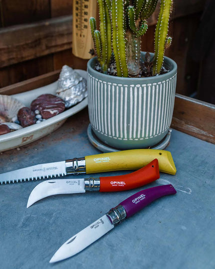 the 3 garden tools included in the set on a garden table alongside a potted cactus
