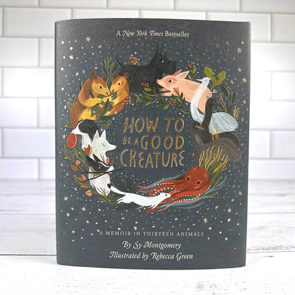 Book titled 'How to Be a Good Creature' with illustrations of animals on a dark background.