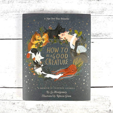 Book titled 'How to be a Good Creature' on a wooden surface