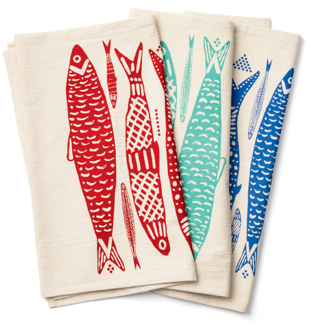 Set of four folded towels with colorful fish designs on a white background