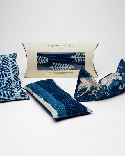 a spread of 3 of the indigo eye pillows out of their packaging, and one within its packaging