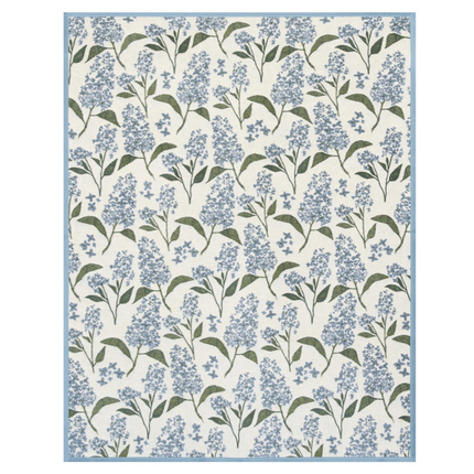 Floral patterned blanket with blue lilac flowers and green leaves on a white background