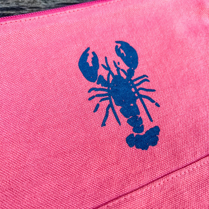 red pouch with a blue lobster design on a textured surface