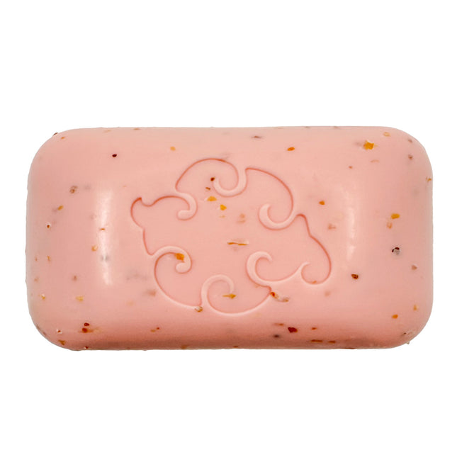 a close up of the pink grapefruit colored soap bar dotted with bits of exfoliating seaweed