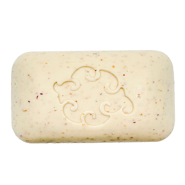 a close up of the Mint Loofa soap bar showing the creamy white color of the soap dotted with bits of exfoliating seaweed