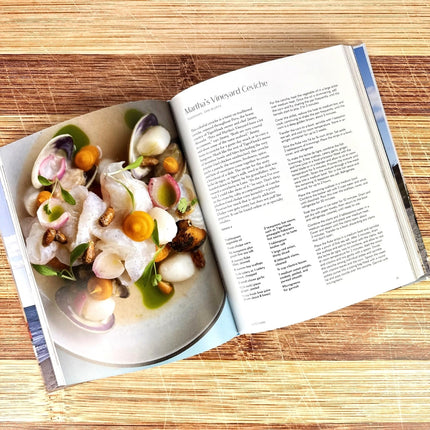 Open cookbook showing a recipe with a plate of food on a wooden surface