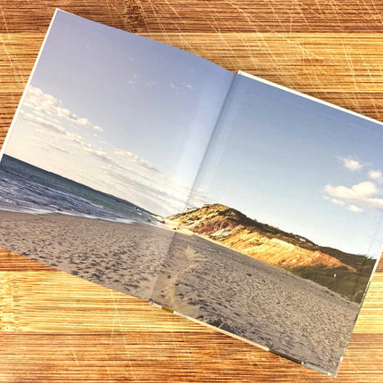 Interior cover page of the Martha's Vineyard Cookbook showing a beach scene with mountains on a wooden surface