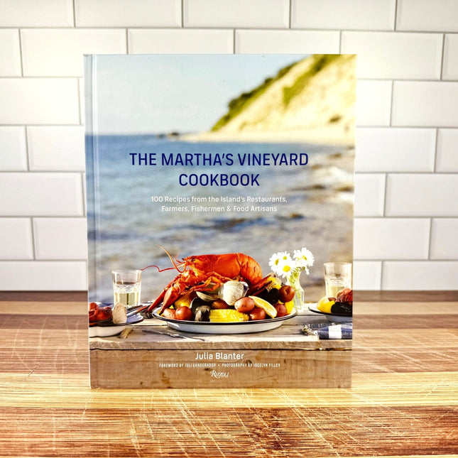 Cookbook titled 'The Martha's Vineyard Cookbook' on a wooden surface with a blurred background