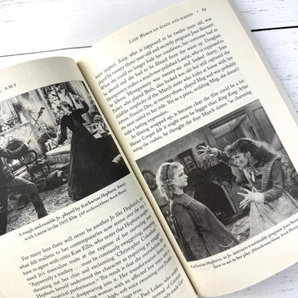 Open book with black and white photos and text on a wooden surface