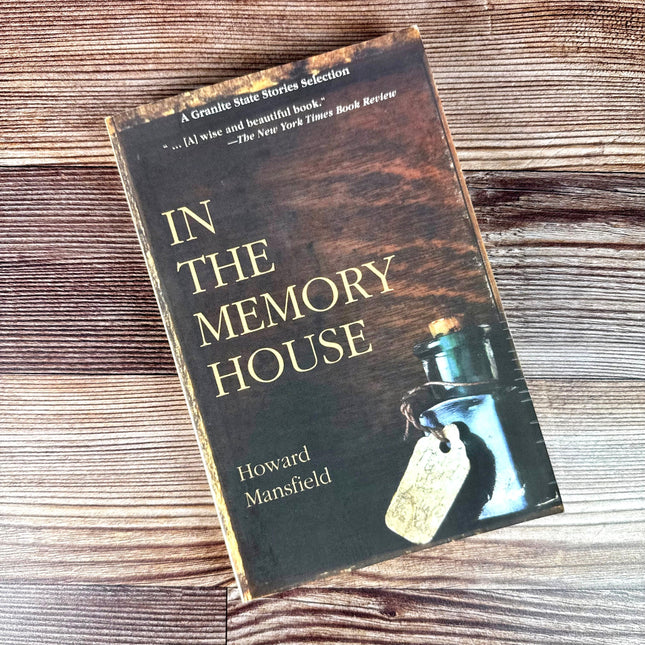 a book titled In the Memory House on a wood surface