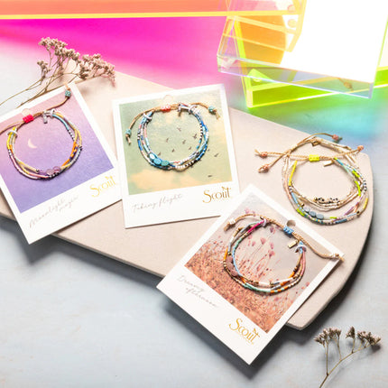 Colorful bracelets on display with cards featuring the brand 'Scout' against a vibrant background.