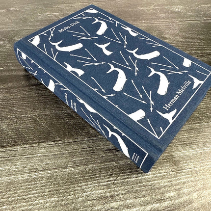Blue book with white text and design on a wooden surface