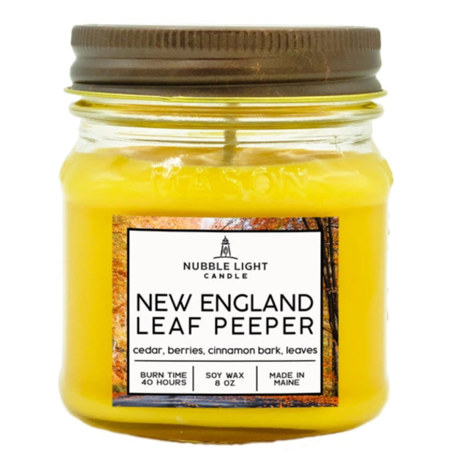 Yellow candle in a glass jar with a brown lid, featuring a label on a white background.