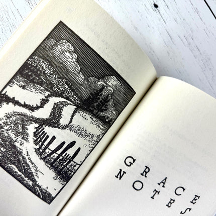 Open book with a black and white illustration on the left page and 'GRACE NOTES' text on the right page.