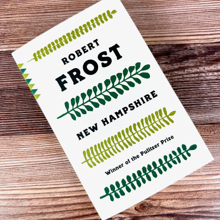 Book cover of 'New Hampshire' by Robert Frost on a wooden surface