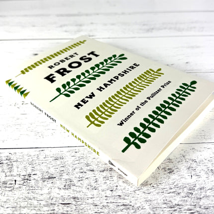 Book titled 'New Hampshire' by Robert Frost on a wooden surface