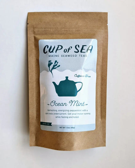 a kraft tea package with a white and blue label that reads "Cup of Sea - Maine Seaweed Teas - Ocean Mint" with a graphic of a solid blue tea kettle with seaweed shaped steam rising out of the spout