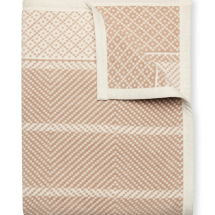 A folded Old Port Herringbone Tan blanket with the top right corner folded over to show the reverse of the design