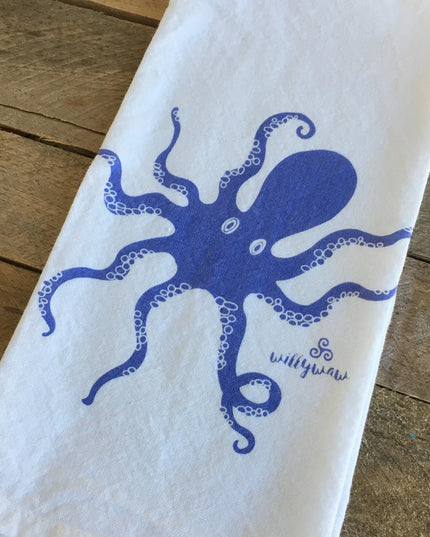 White towel with blue octopus design on a wooden surface