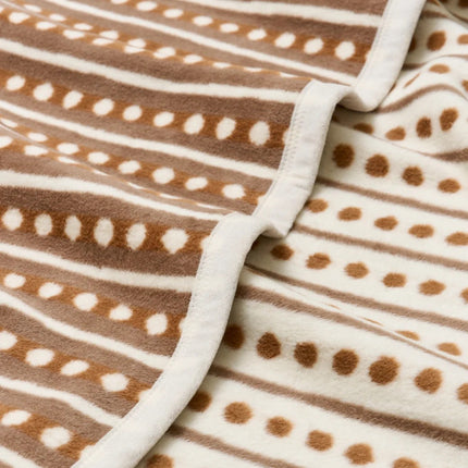Close-up of a brown and white patterned fabric with stripes and dots.