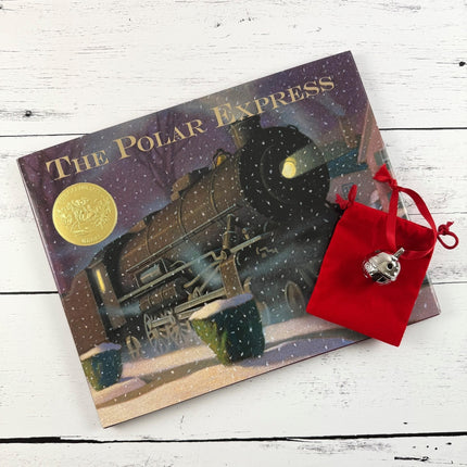 Book titled 'The Polar Express' with a red pouch containing a bell on a wooden surface