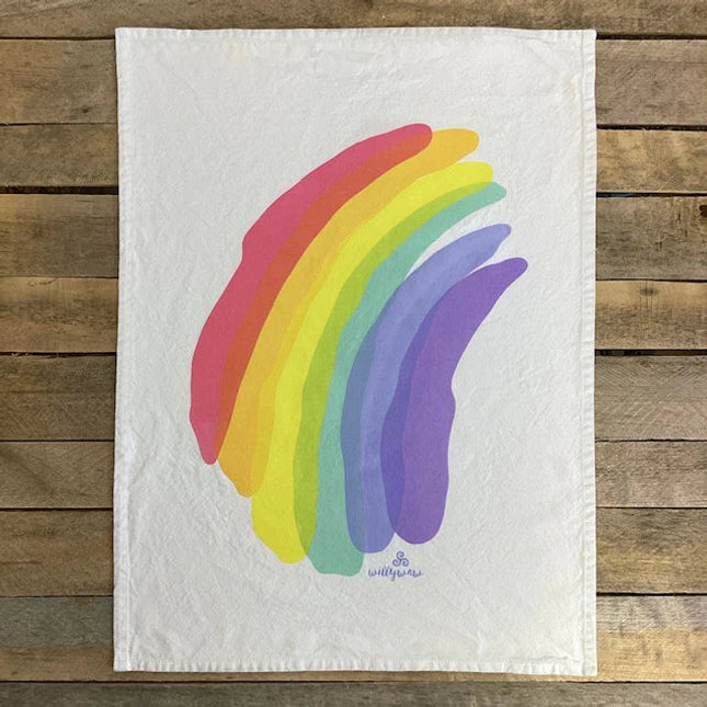 a white cotton tea towel with handprinted rainbow illustration in loose washes of color with overlapping colors