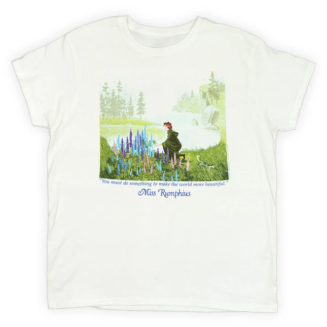 White t-shirt with a book illustration from Miss Rumphius with the title character kneeling to admire a crop of Lupine flowers against a coastal Maine landscape