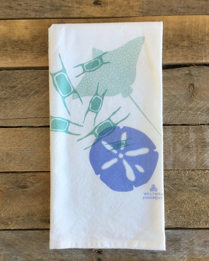 Folded towel with sand dollar design on a wooden surface