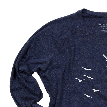 Navy long-sleeve shirt with white bird designs on a white background