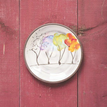 Decorative plate with colorful floral design of 4 trees portrayed in their states through the seasons