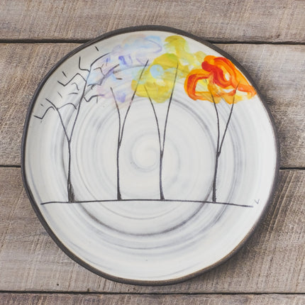 Decorative plate with tree design featuring four trees with their changing foliage through the seasons