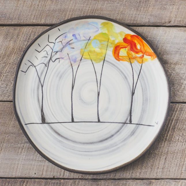 Decorative plate with tree design featuring four trees with their changing foliage through the seasons