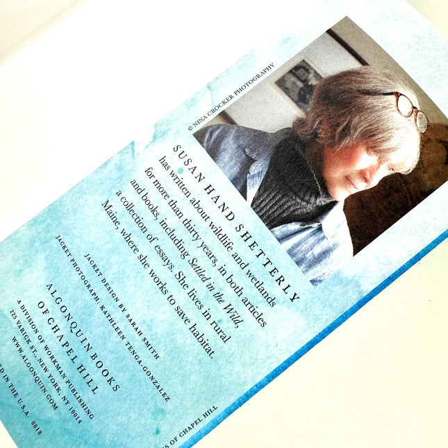 Book with a blue watercolor design and text overlay on a white background