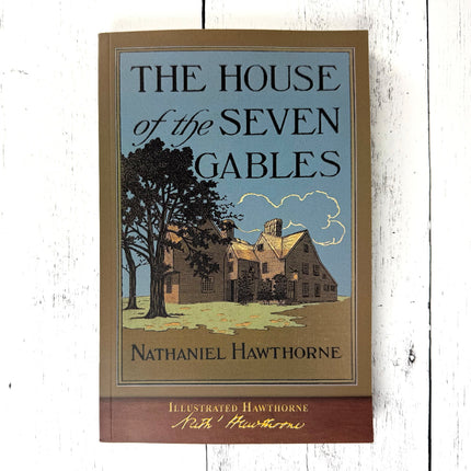 The Book - House of the Seven Gables - with vintage illustration on cover featuring the titular Salem, MA house, laid on a white wood surface