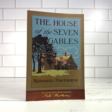 The House of the Seven Gables book on a white wood surface with white tile in the background