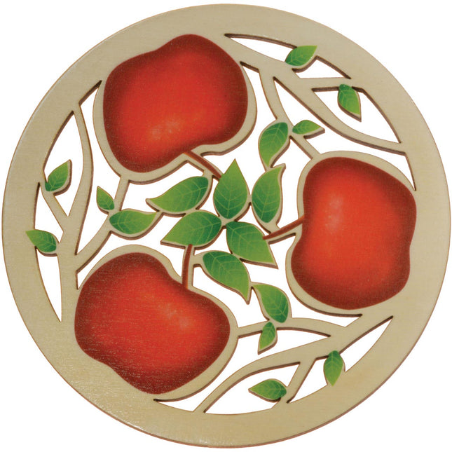 a round trivet with laser cut apple and branch design with red painted apples and green leaves