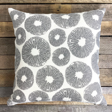 Decorative pillow with circular pattern on a wooden background
