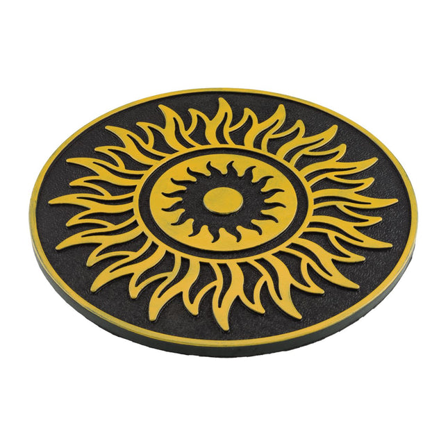 A circular black and yellow sun design plaque or coaster on a plain white background.