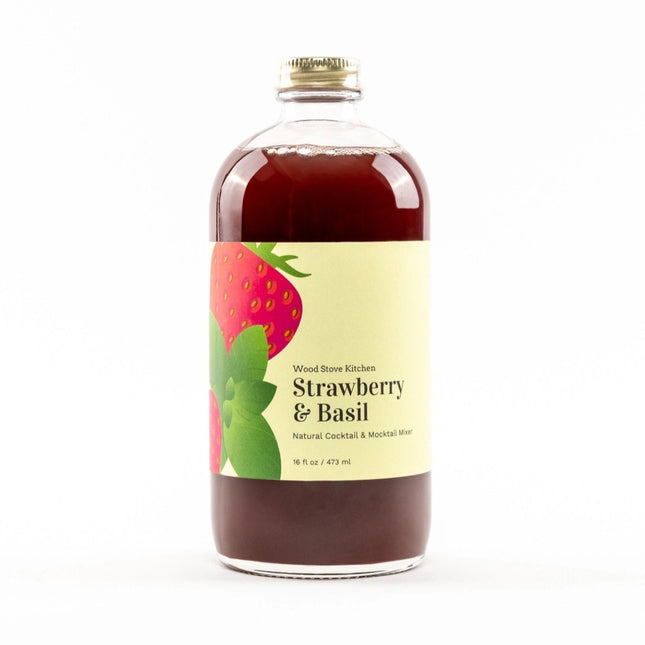a glass bottle filled with red Strawberry & Basil drink mixer with a yellow label and strawberry and basil illustration on it