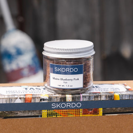Jar of Skordo Maine Blueberry Pork Rub on a gift box with Skordo branding.