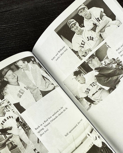 Open book with black and white photographs of baseball players on a wooden surface