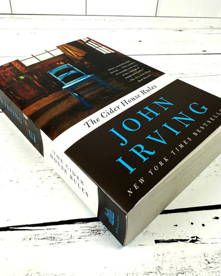 Book titled 'The Cider House Rules' by John Irving on a wooden surface
