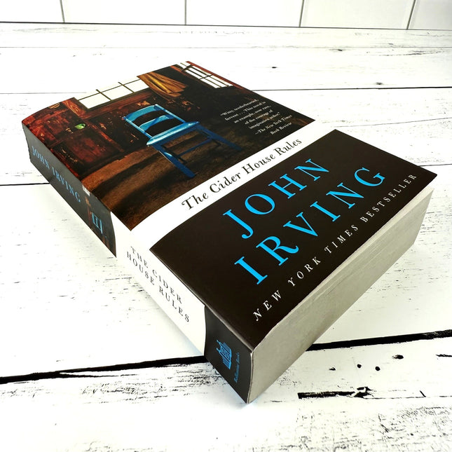 Book titled 'The Cider House Rules' by John Irving on a wooden surface