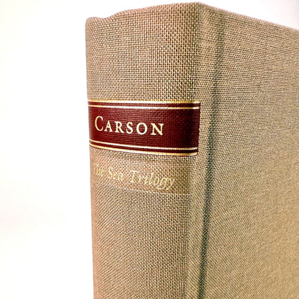Beige book with a red label and gold text on a white background