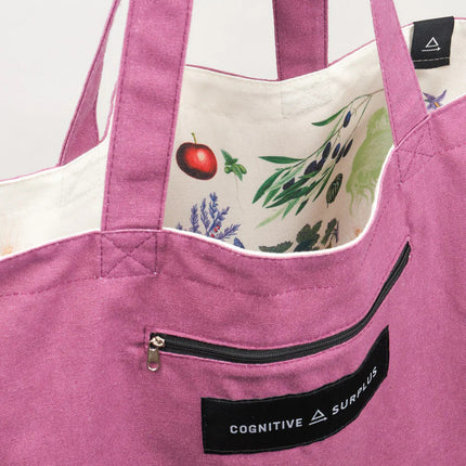 a close up of the tote near the handles showing the bag reversed so the fruit and veggie print is on the inside of the tote and the outside is now a warm lavender