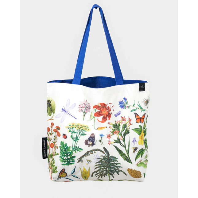 side two of the pollinator tote; a white tote bag with blue straps covered in vintage illustrations of hummingbirds, bees, butterflies, and the plants they pollinate