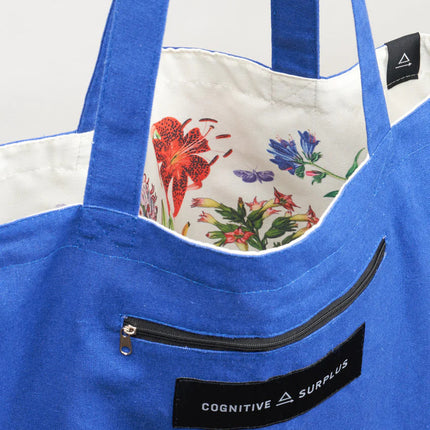 a close up of the tote near the handles showing the bag reversed so the pollinators print is on the inside of the tote and the outside is now a royal blue