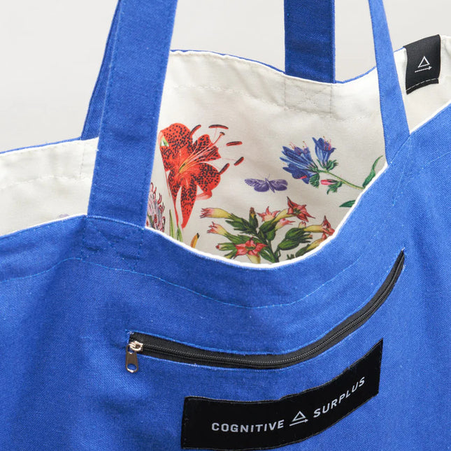a close up of the tote near the handles showing the bag reversed so the pollinators print is on the inside of the tote and the outside is now a royal blue