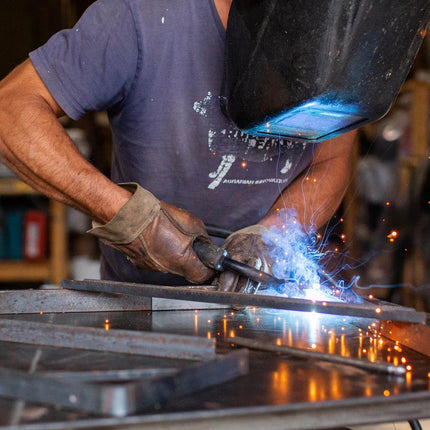 a welder wearing the vermoter gloves in a workshop
